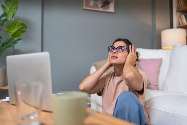 Young Nervous Sick Frustrated Woman Working At Home Office On Laptop Computer, Migraine Head Pain Or Stressed Because Loud Noise From Apartment Above. Freelancer Female Or College Student Stress.